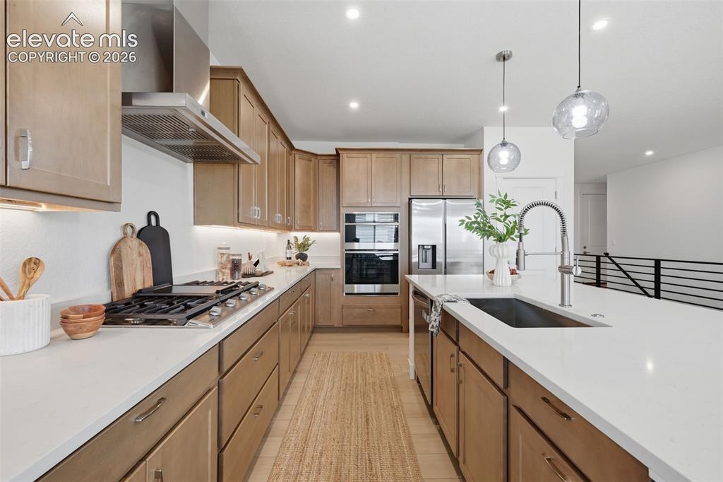 Image 14 of 49: Kitchen with pantry,gas cook top, oven and microwave and stainless vent hoo