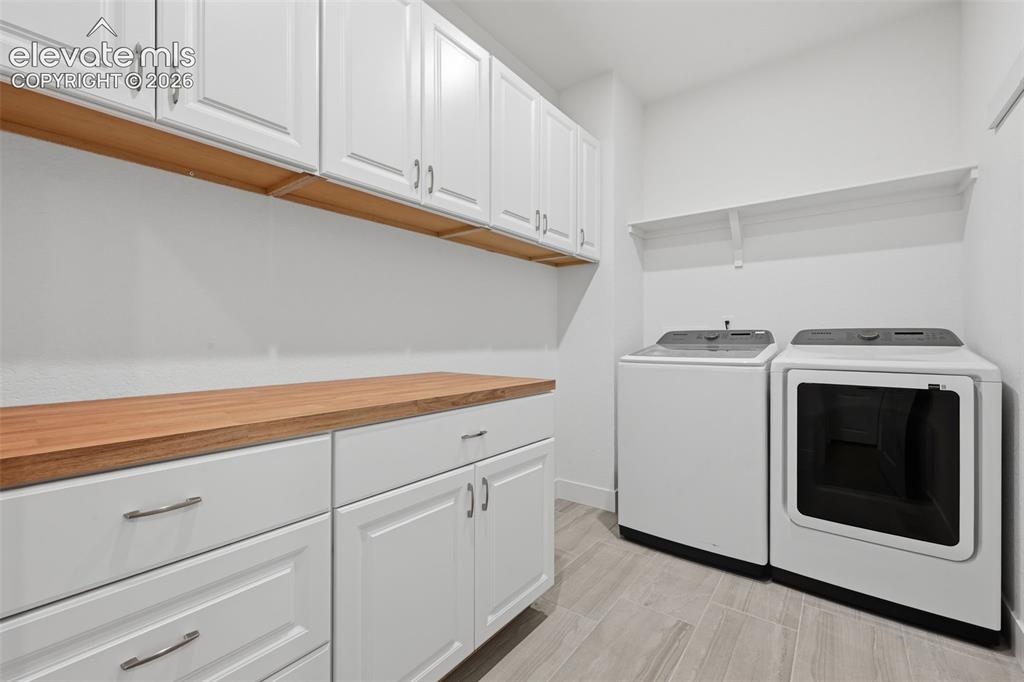 Image 27 of 44: main level laundry with countertop, cabinets, and new washer/dryer