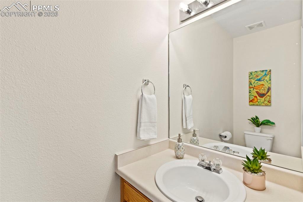 Image 10 of 26: Half bathroom featuring vanity and toilet