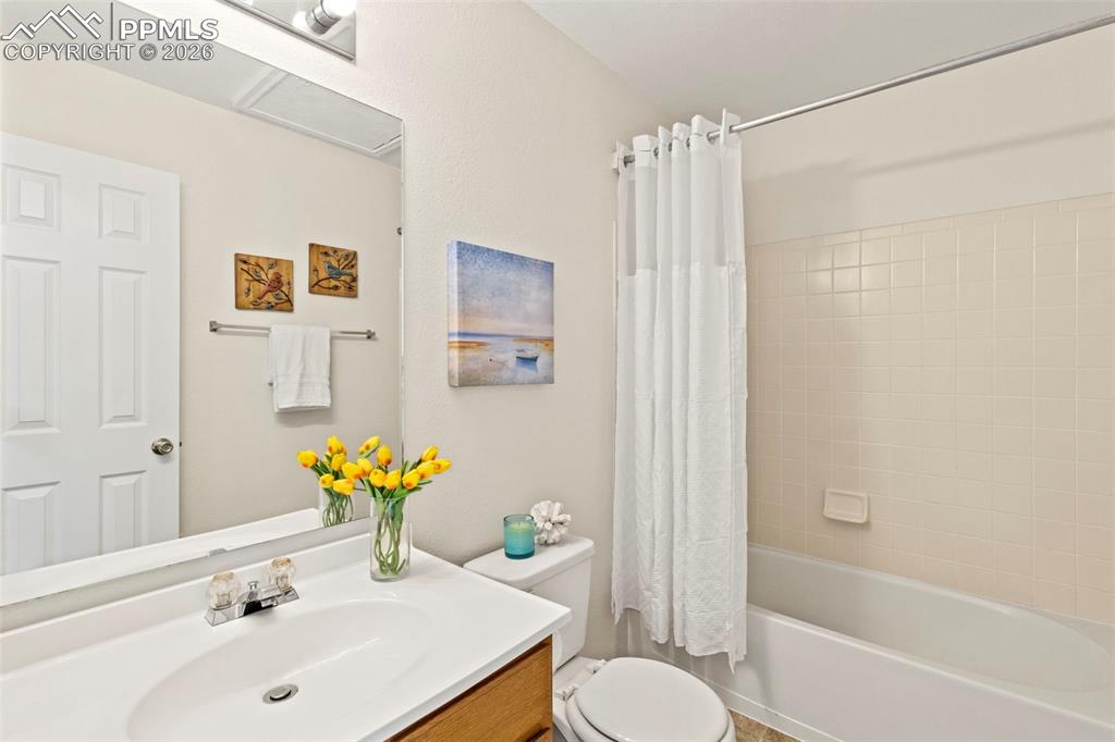 Image 17 of 26: Bathroom with vanity and shower / tub combo with curtain