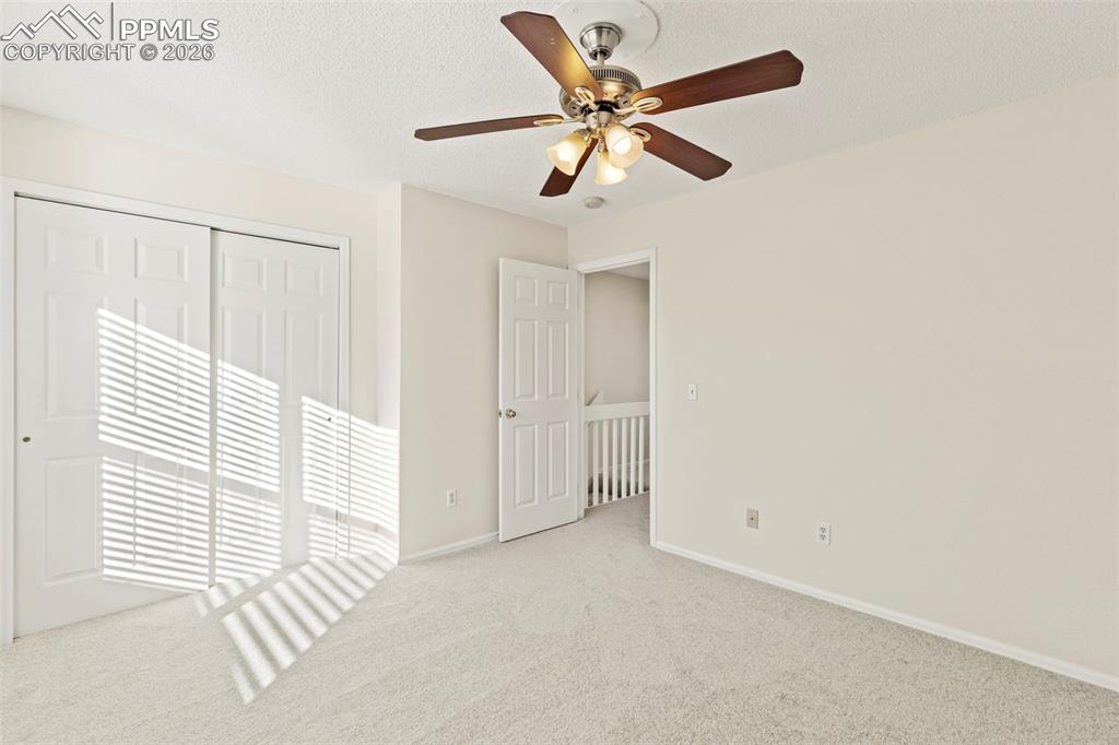 Image 19 of 26: Unfurnished bedroom with carpet floors, a closet, a ceiling fan, and a text