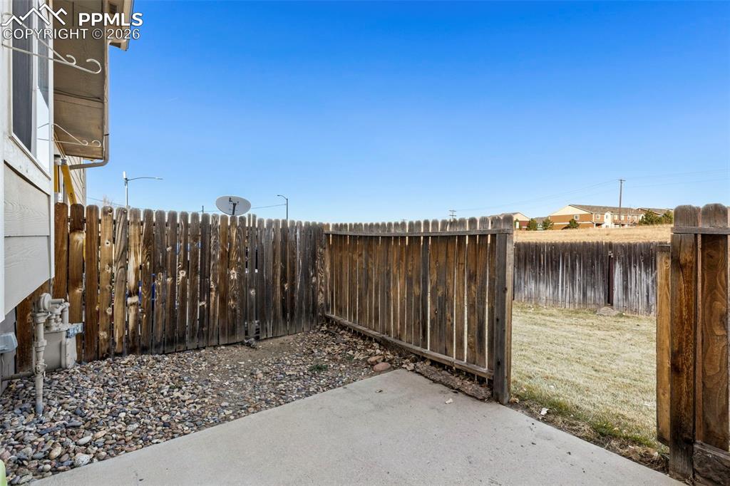 Image 21 of 26: Fenced backyard with a patio area and access to common open space