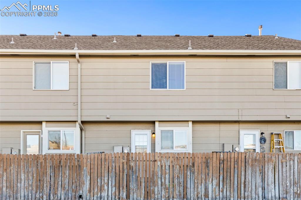 Image 24 of 26: Back of house featuring a shingled roof