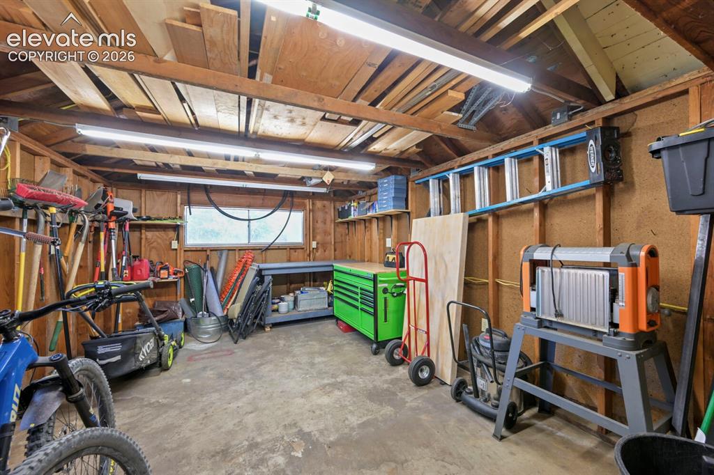 Image 29 of 36: The rear portion of the two car garage currently utilized as a shop and sto