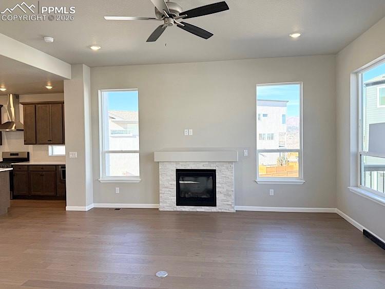 Image 14 of 49: Spacious Great Room featuring a gas fireplace with a beautiful stone surrou