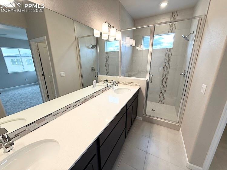Image 27 of 49: Primary bathroom featuring double sinks, a quartz countertop, and a decorat