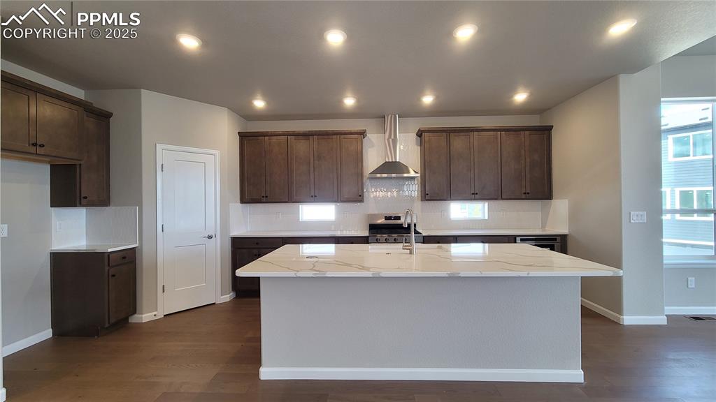 Image 6 of 49: Kitchen with Quartz countertops, pantry, large island providing additional