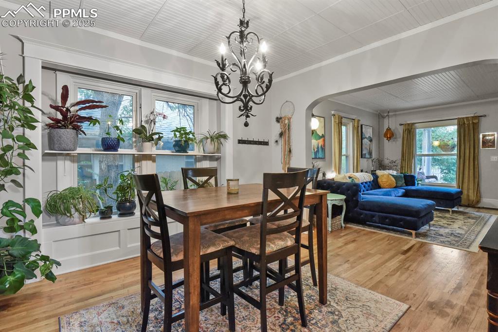 Image 10 of 36: Dining space featuring arched walkways, ornamental molding, light wood-styl