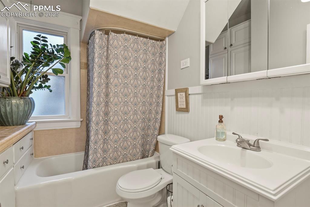 Image 17 of 36: Bathroom featuring vanity, shower / bath combo with shower curtain, and a w
