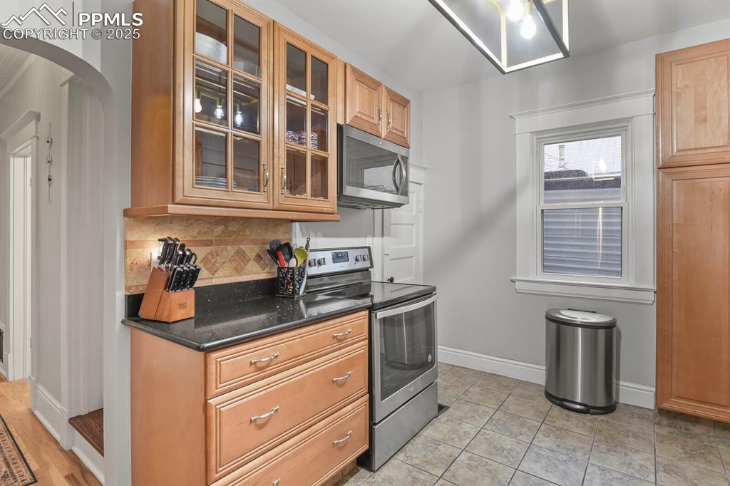 Image 21 of 36: Kitchen featuring stainless steel appliances, tasteful backsplash, brown ca