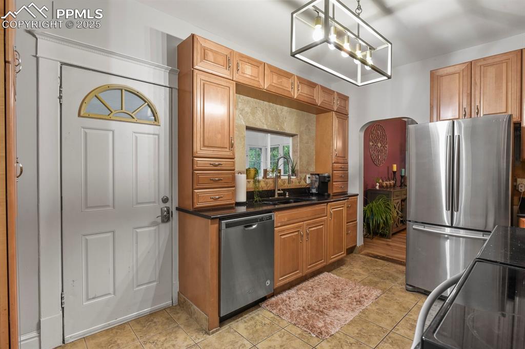 Image 22 of 36: Kitchen with appliances with stainless steel finishes, decorative light fix