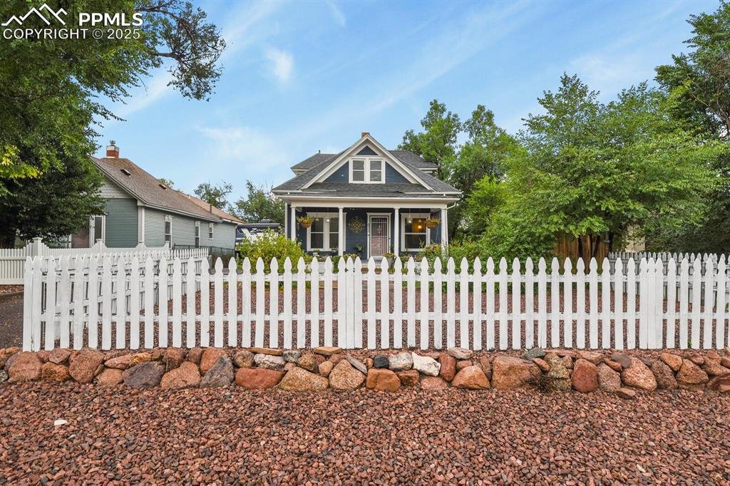 Image 6 of 36: View of front of home with a fenced front yard, roof with shingles, and a p