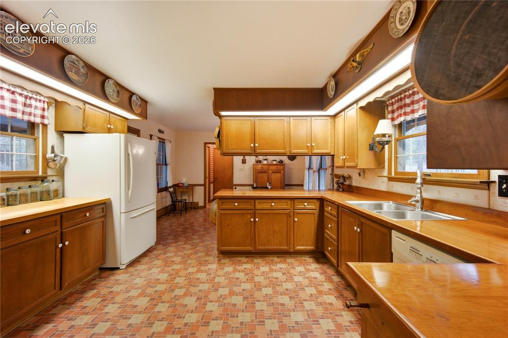 Image 17 of 50: The family room radiates warmth with rich wood-paneled walls, rustic beamed