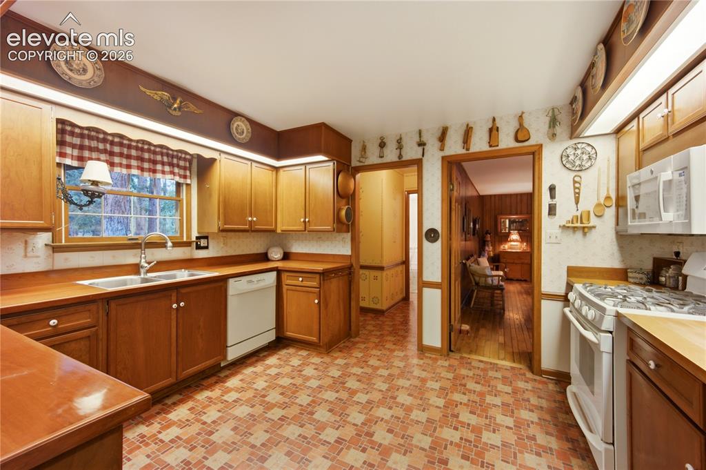 Image 19 of 50: The coveted main-level primary retreat features stunning hardwood floors an