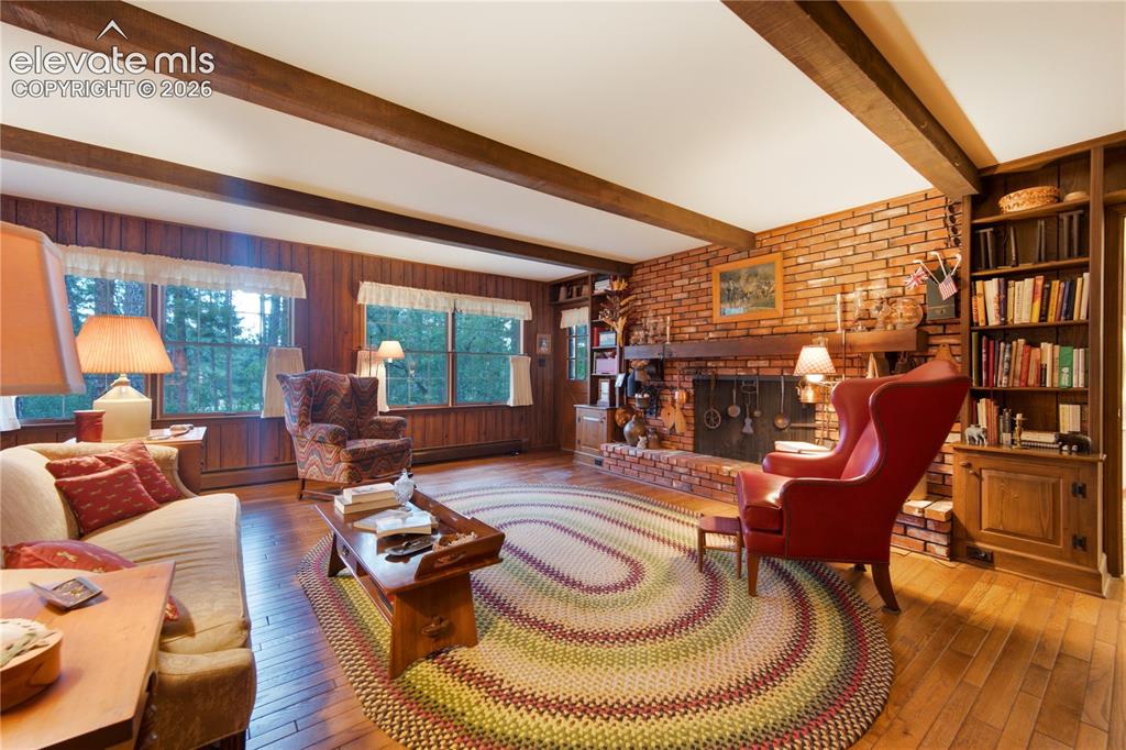 Image 27 of 50: The formal, light-filled living room features elegant crown molding and plu
