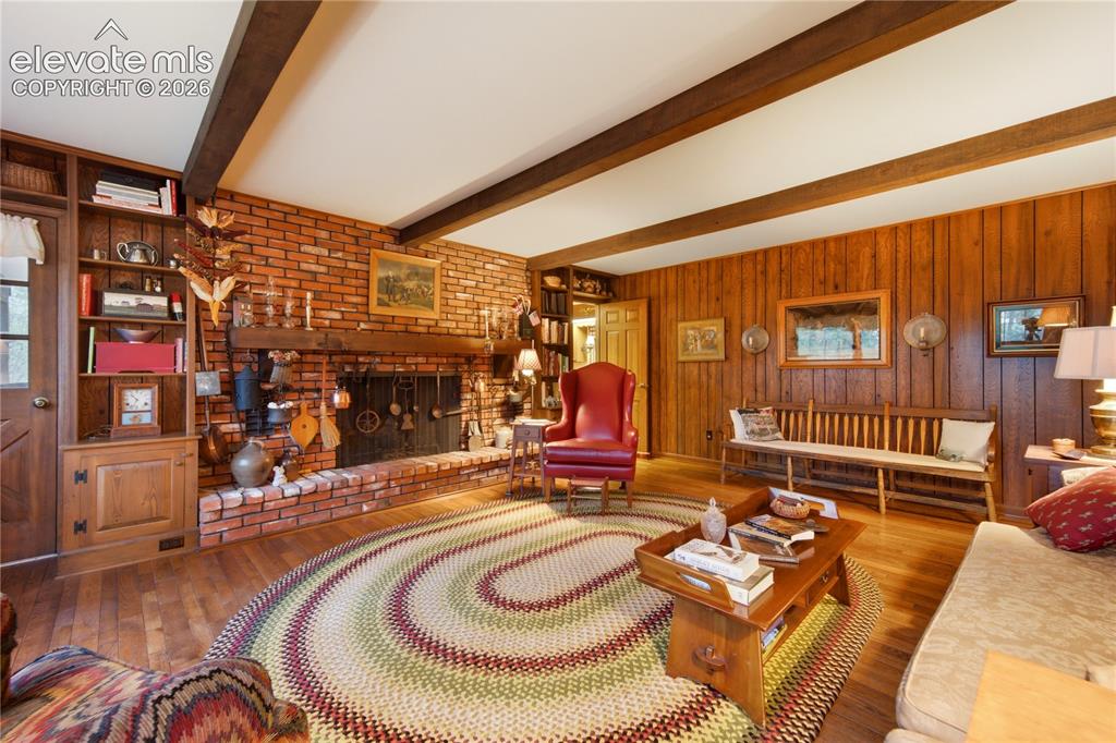 Image 28 of 50: A classic wood-burning fireplace with a detailed white mantel anchors the f