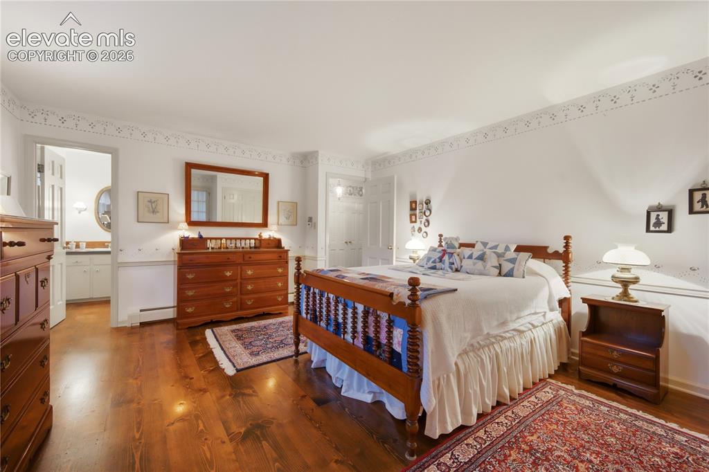 Image 30 of 50: Another charming upstairs bedroom offers peaceful privacy with natural wood