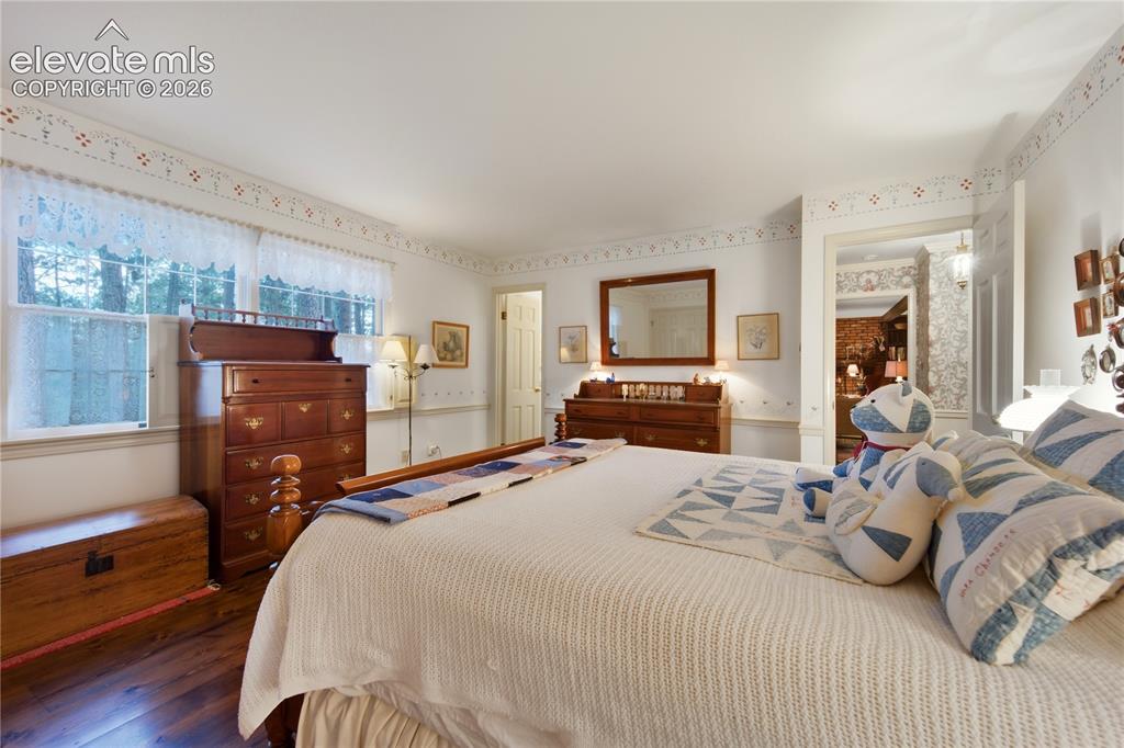 Image 31 of 50: This bright upper-level guest bedroom provides stunning views of the surrou