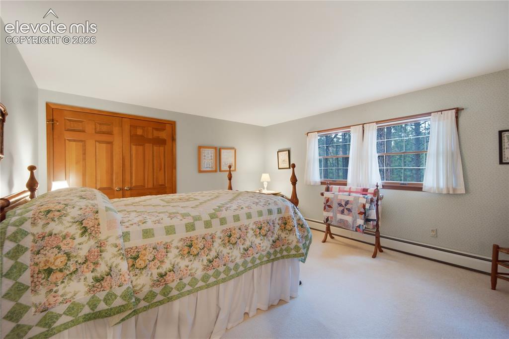 Image 35 of 50: This upper-level bedroom features a cozy dormer alcove and beautiful hardwo