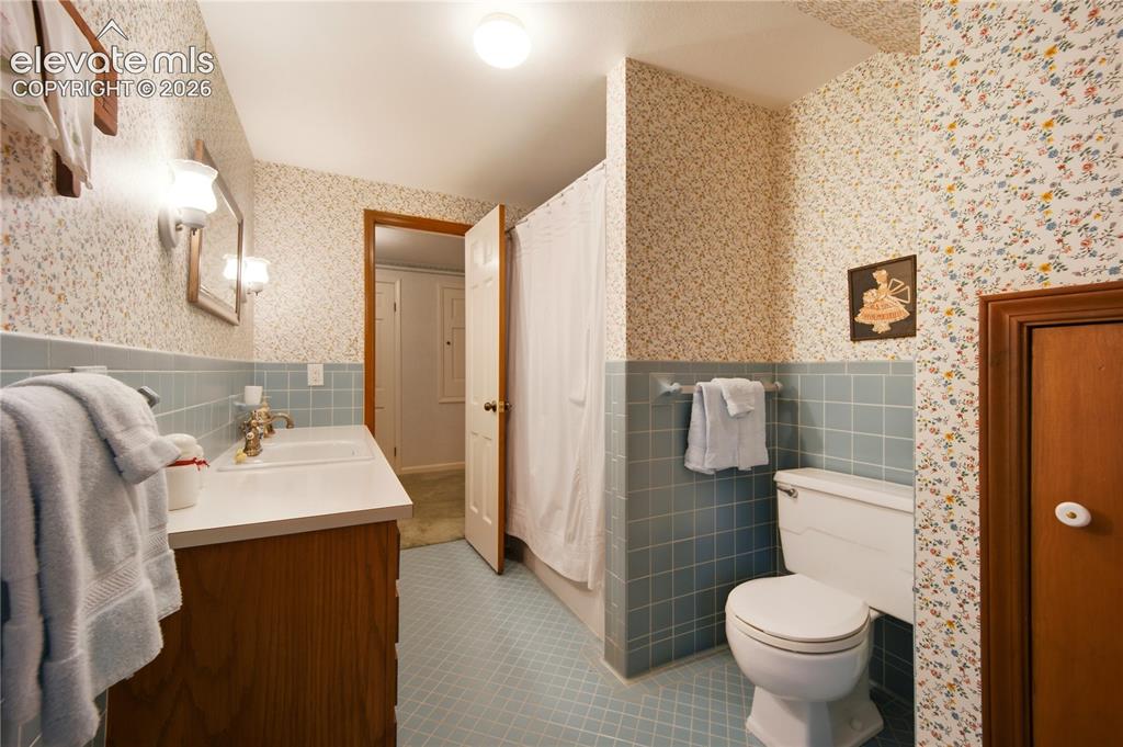 Image 37 of 50: The blue bathroom offers classic fixtures and serves the upper-level guest 