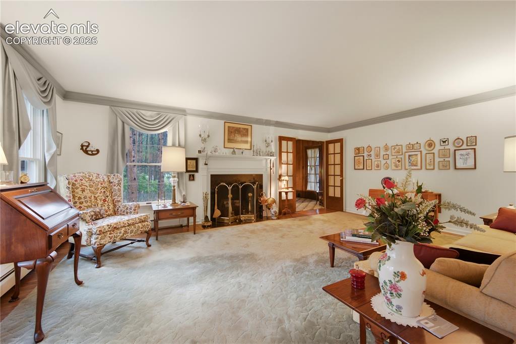 Image 7 of 50: A gracious, light-filled entryway with classic wallpaper and a grand stairc