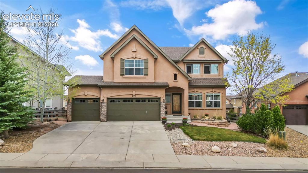 Image 1 of 50: Stucco exterior residence with a multi-gabled roofline and attached three-c