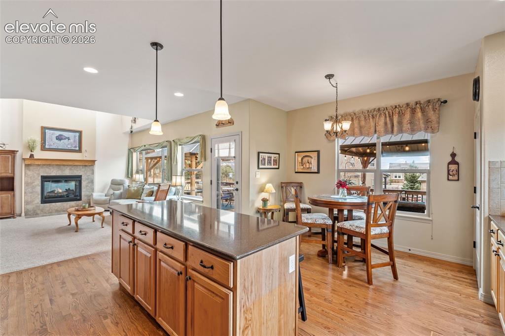 Image 18 of 50: Open-concept living space featuring a central kitchen island with counterto