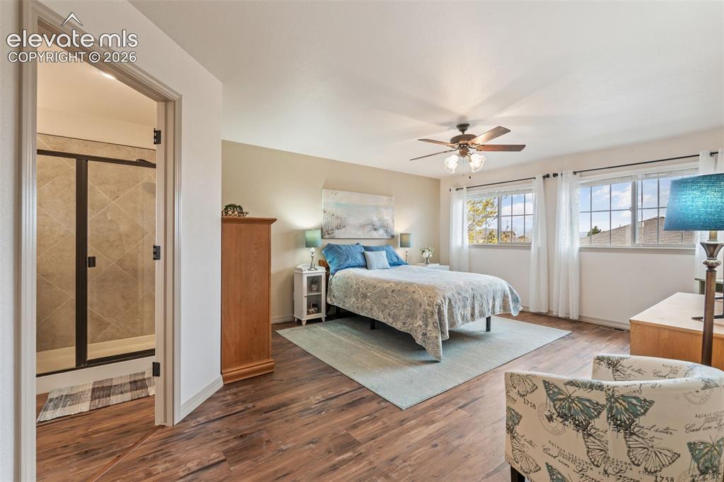 Image 27 of 50: Spacious room featuring wood-finish flooring, two window openings, and a ce