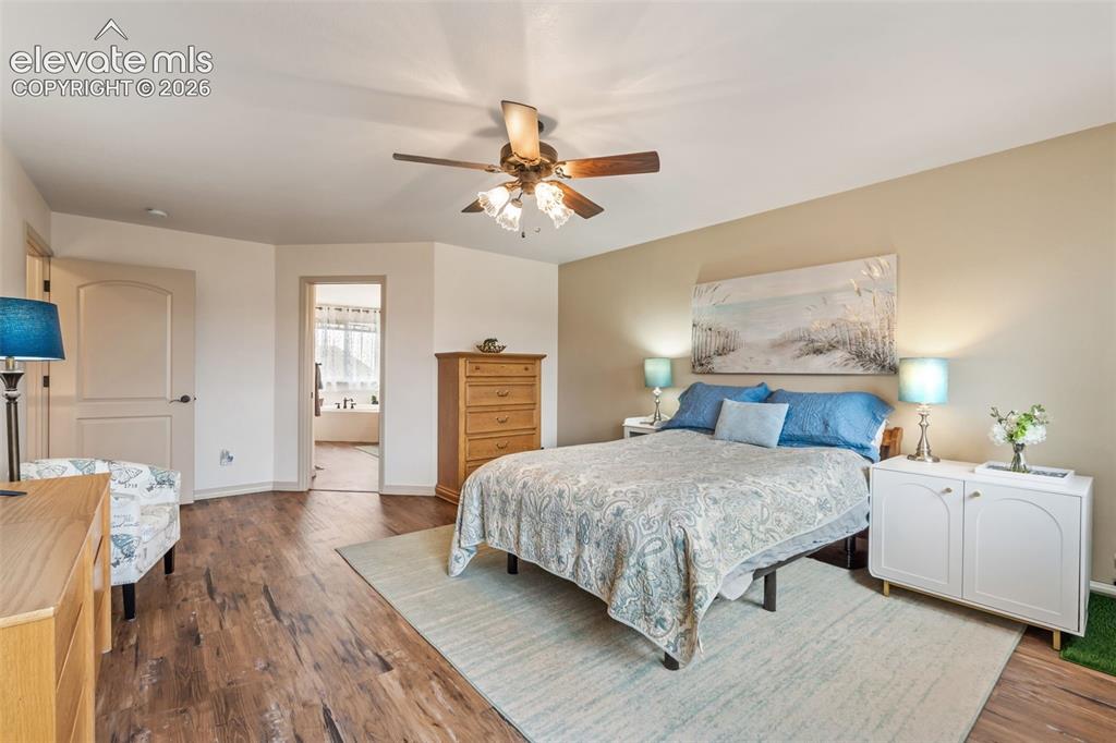 Image 28 of 50: Bedroom featuring wood-finish flooring, a ceiling fan with integrated light