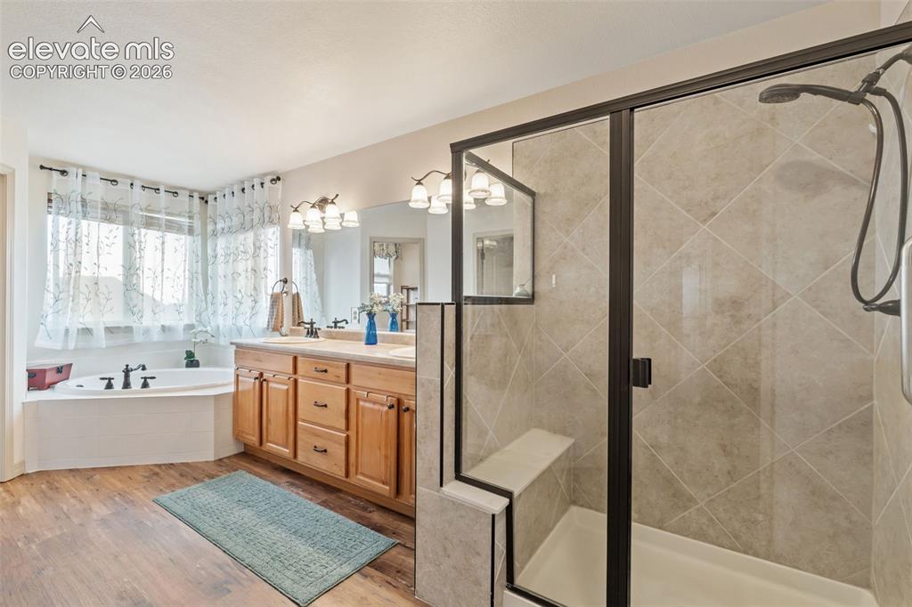 Image 30 of 50: Bathroom featuring a glass-enclosed shower with tile surround, a built-in s