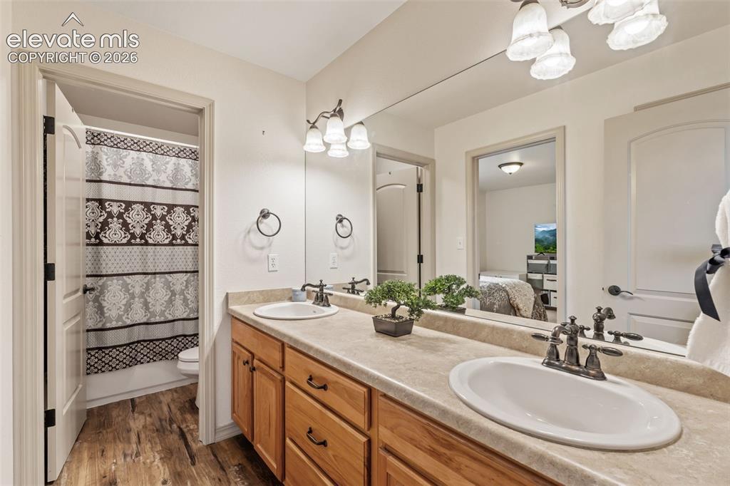 Image 33 of 50: Dual vanity with wood cabinetry and light-toned countertops
