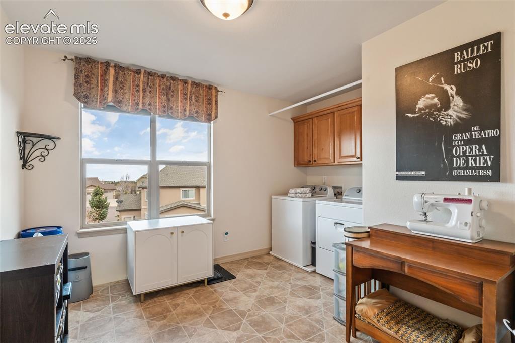 Image 36 of 50: Dedicated laundry area featuring a large window, tiled flooring, wood cabin