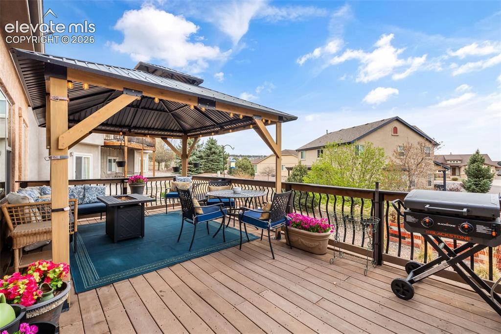 Image 37 of 50: Expansive outdoor deck featuring a built-in pergola with a metal roof and s