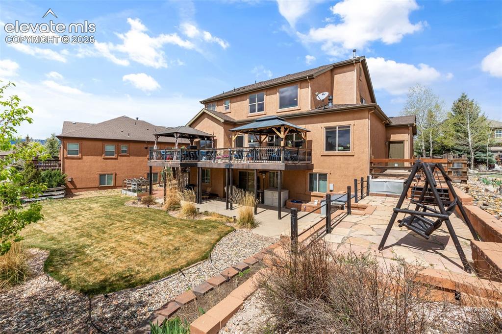 Image 43 of 50: Multi-level rear exterior featuring a deck with a built-in gazebo, lower-le