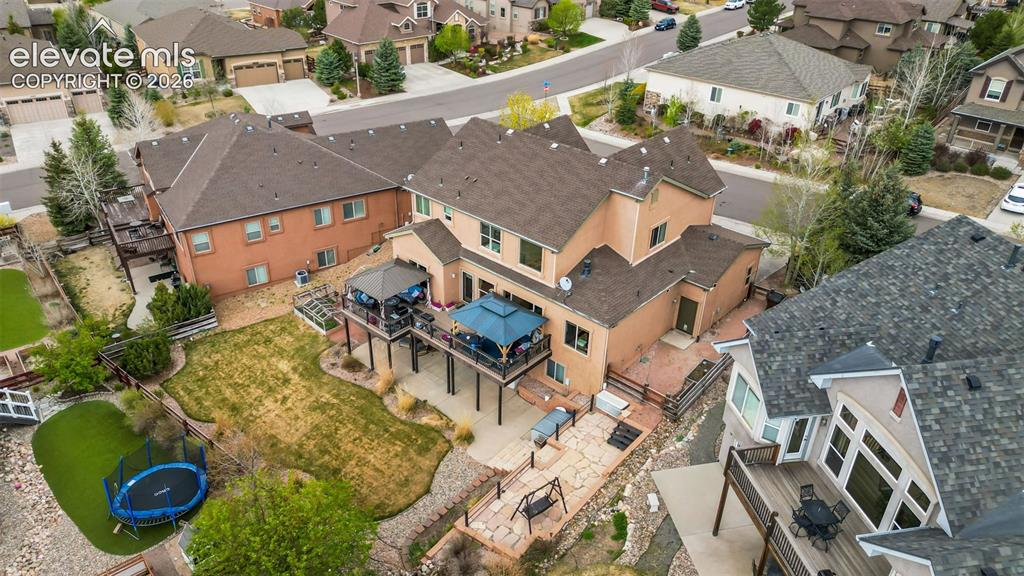 Image 49 of 50: Expansive backyard featuring a large raised deck, multi-level flagstone pat