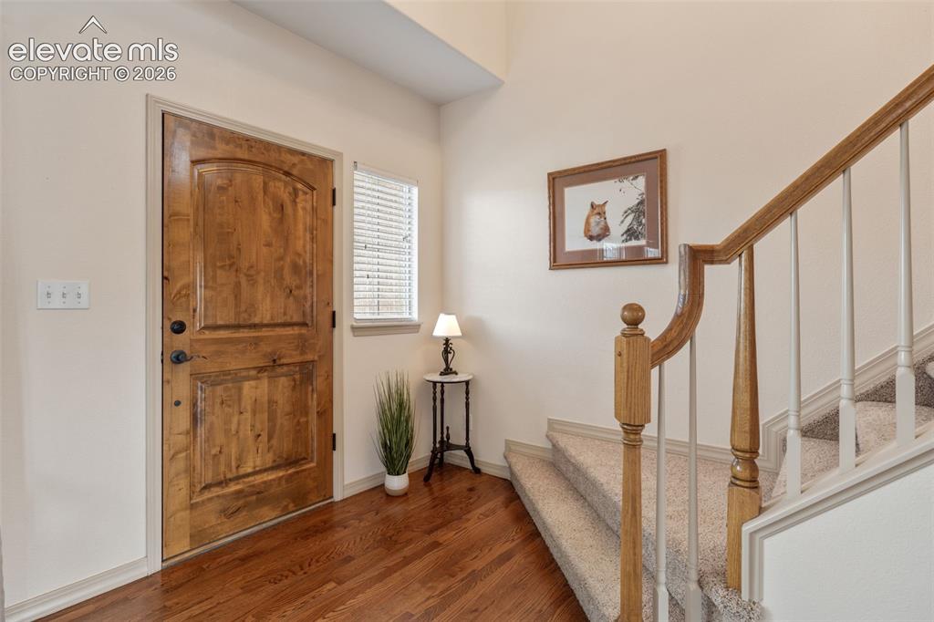 Image 5 of 50: Crafted wood-grain entry door with dark hardware