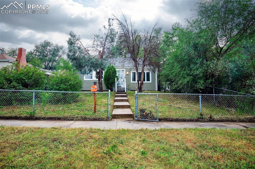 Caption: View of front facade featuring a fenced front yard and a gate