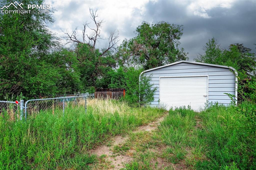 Image 12 of 12: Detached garage accessible via alley. Single overhead door with additional