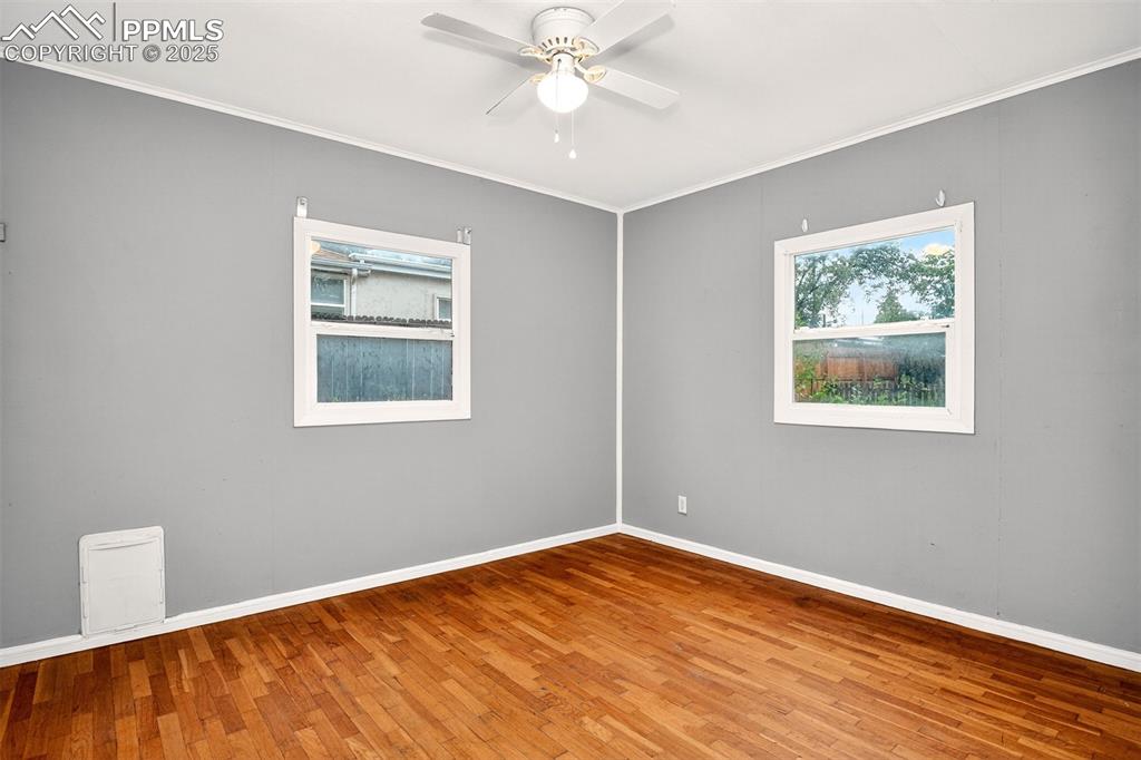 Image 9 of 12: Bedroom featuring wood finished floors, crown molding, and ceiling fan