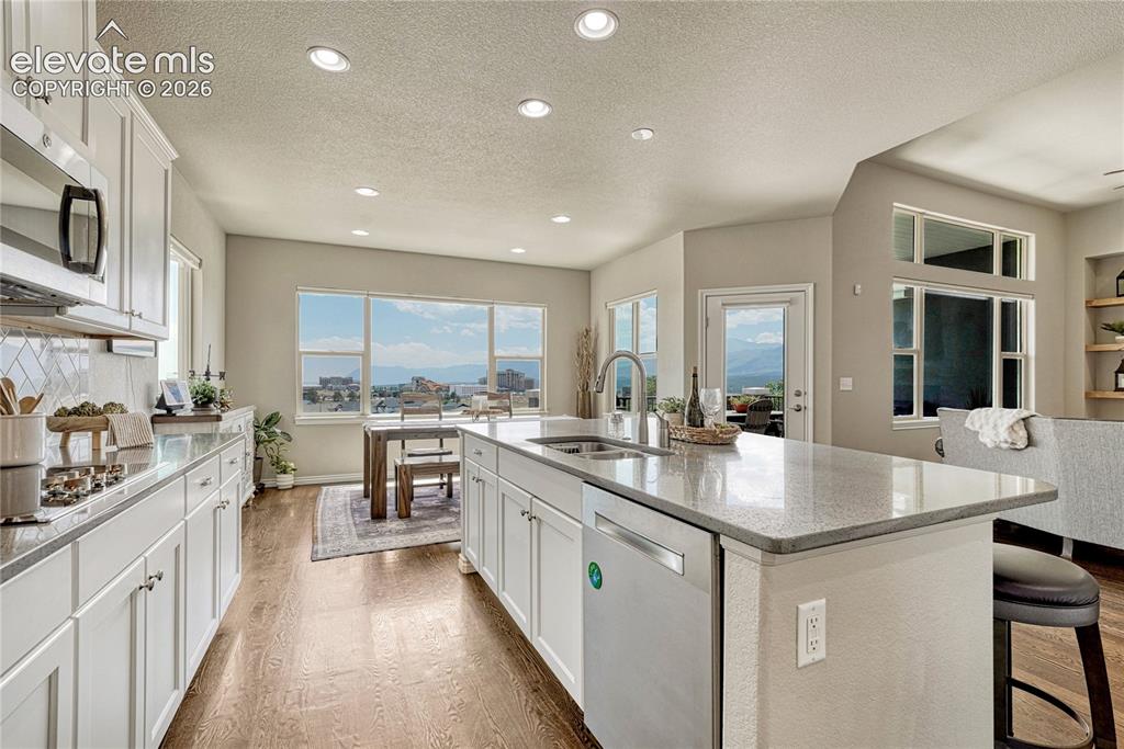 Image 14 of 50: The functional central island features a deep stainless steel sink, goosene