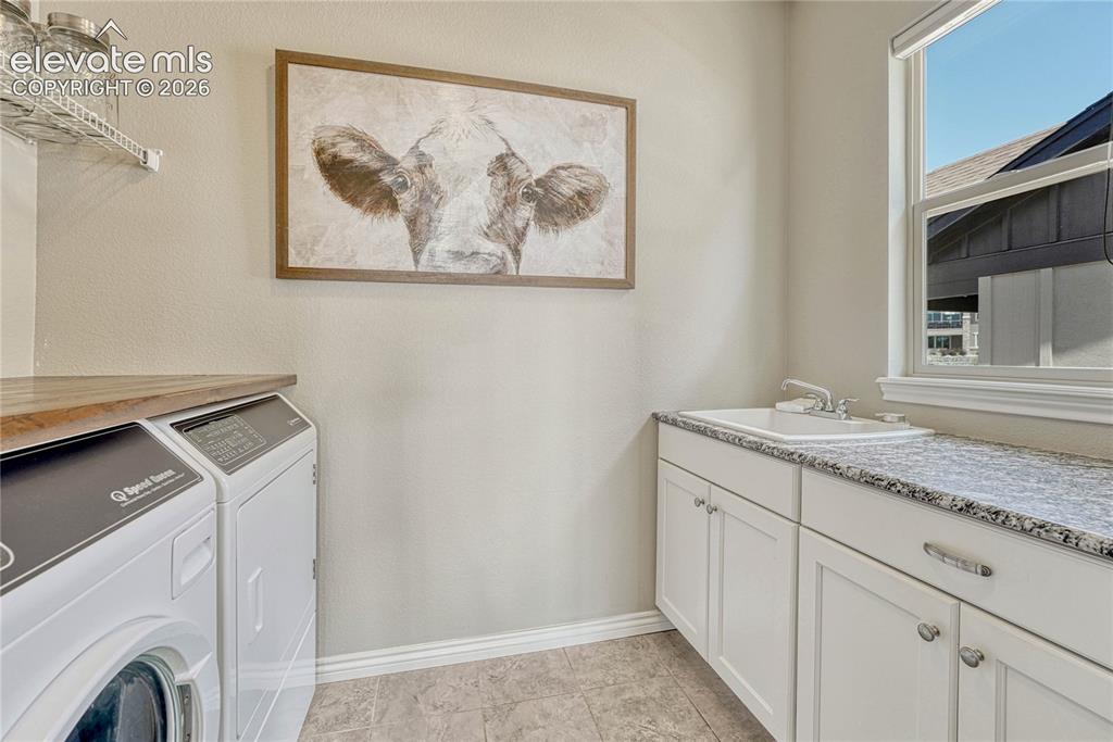 Image 17 of 50: The convenient main-level laundry room comes complete with solid granite co