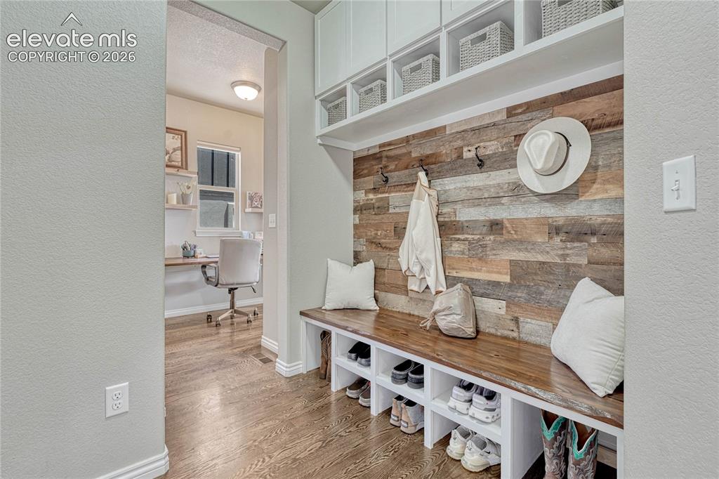 Image 18 of 50: A highly customized mudroom near the garage entry features a beautiful recl