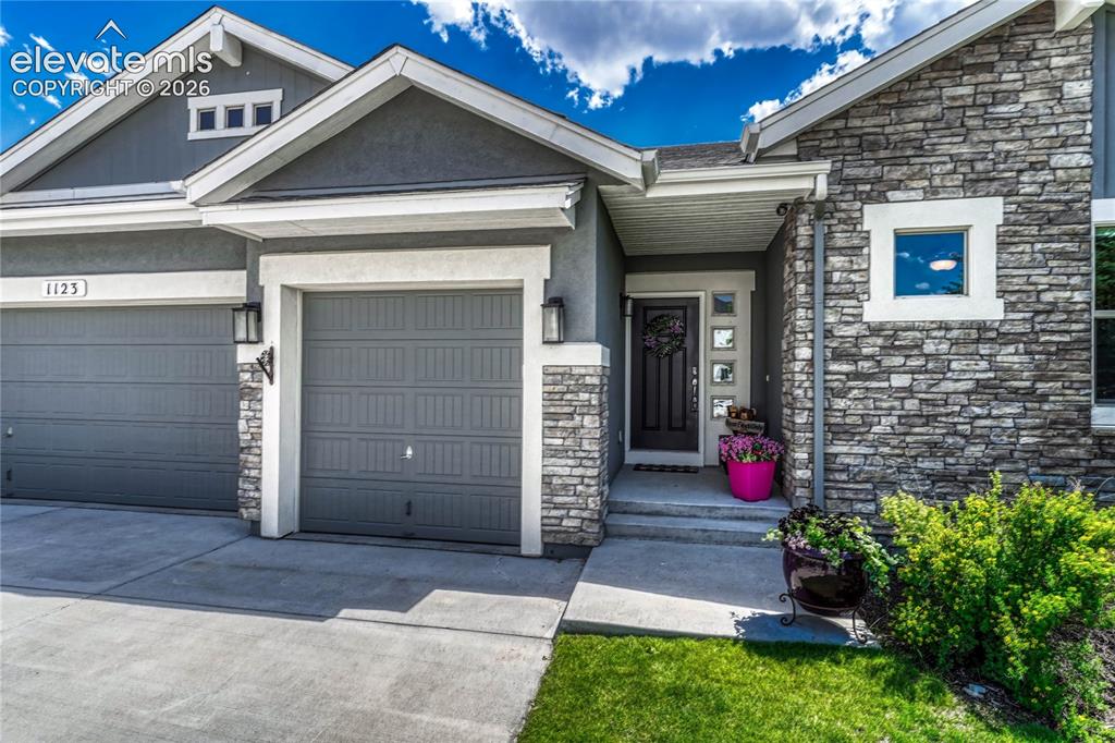 Image 2 of 50: The charming stone-accented front entryway features classic stucco detailin