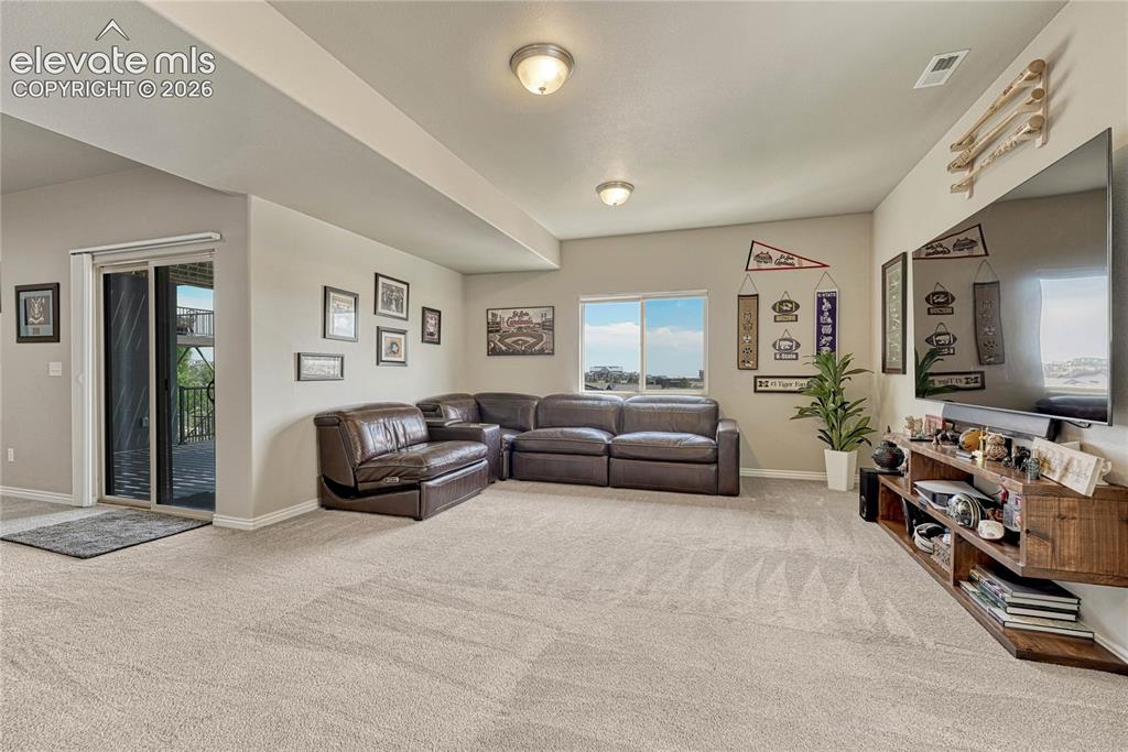 Image 28 of 50: The cozy basement family room is perfect for movie nights and features a sl