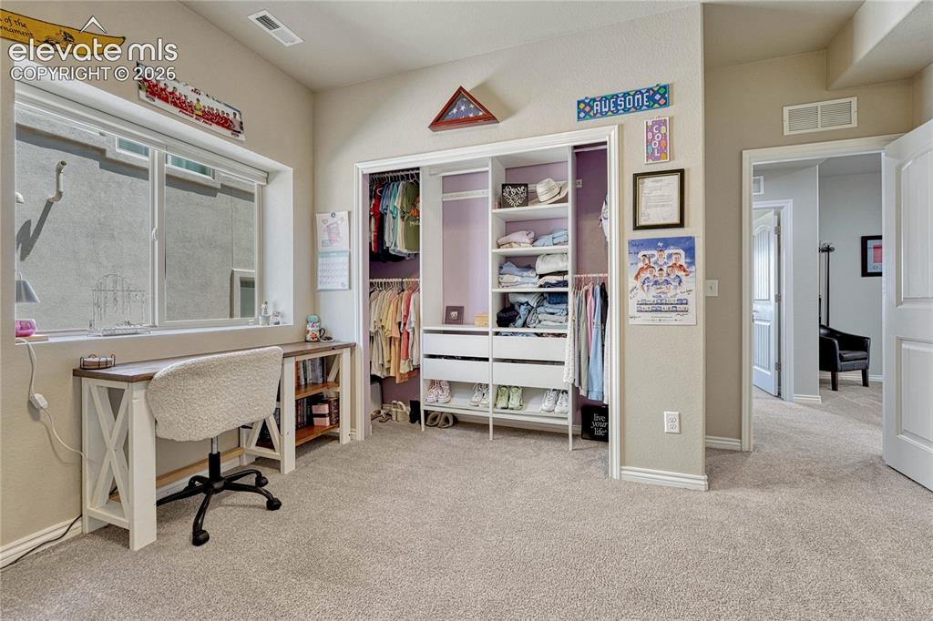 Image 36 of 50: The bedroom offers a custom built-in closet organizer with adjustable shelv