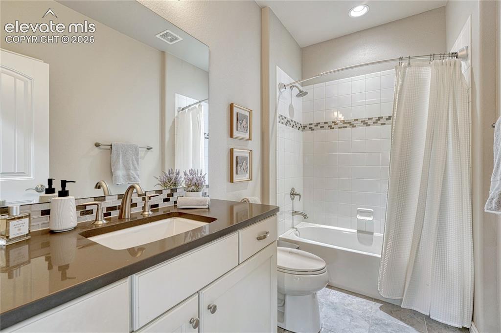 Image 37 of 50: A bright and pristine full basement bathroom features a classic tub/shower