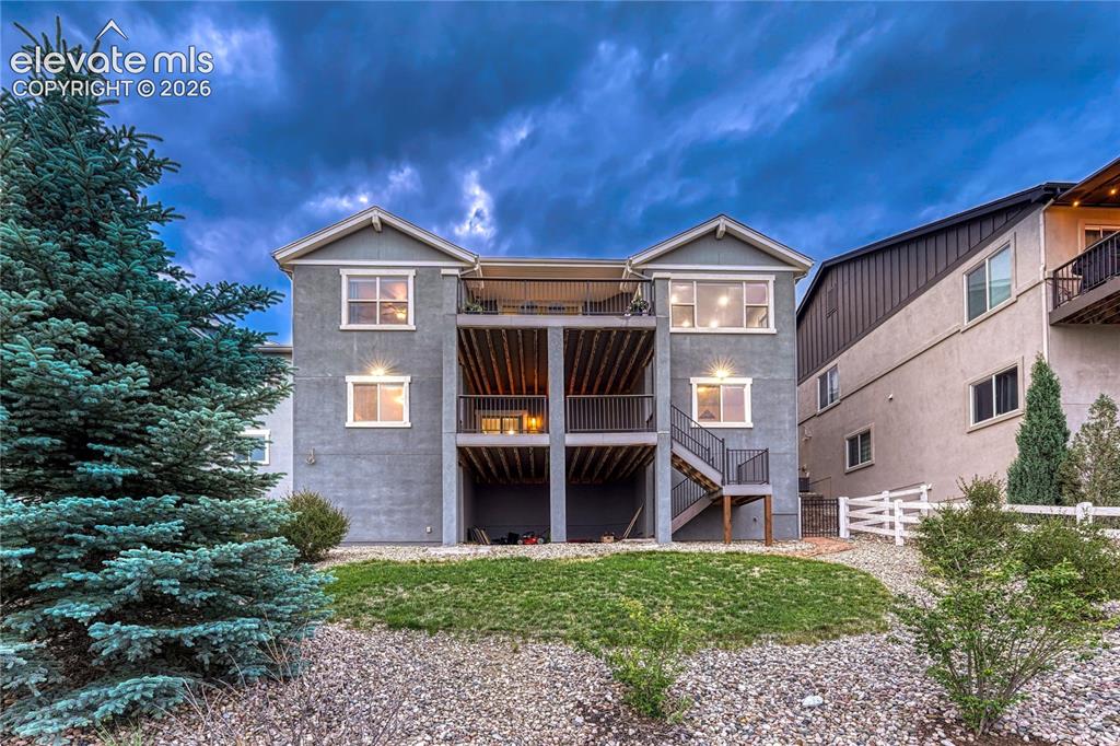 Image 44 of 50: The stately rear exterior of the home highlights the magnificent two-tier c