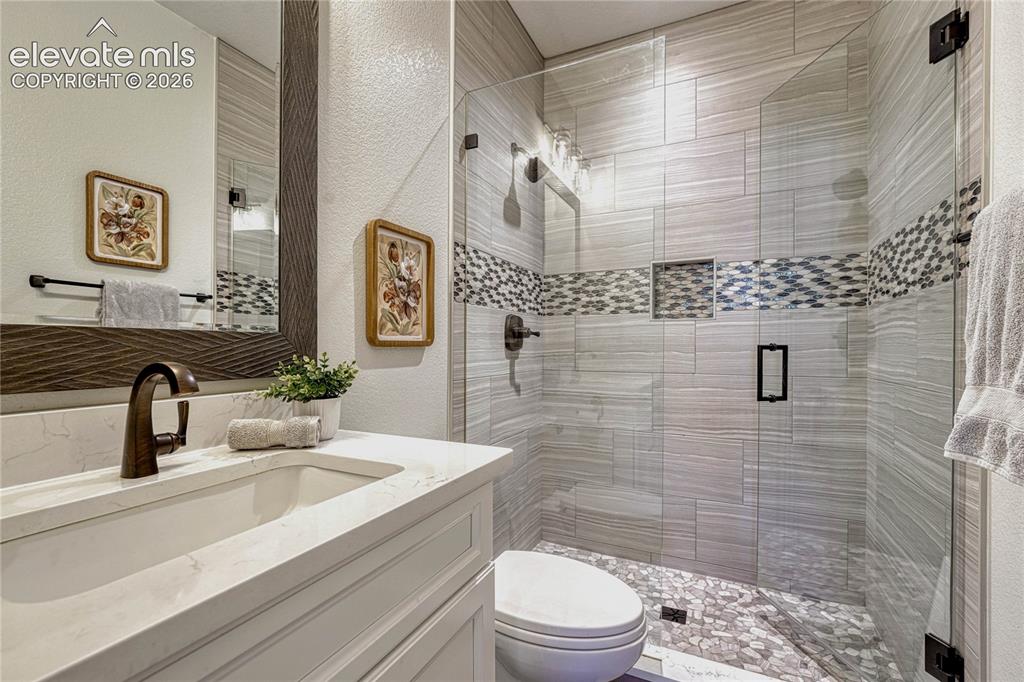 Image 5 of 50: This beautifully remodeled main-level bathroom features a custom walk-in sh