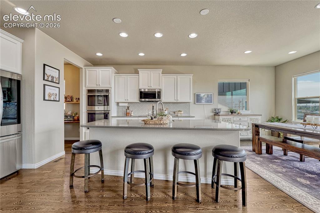 Image 9 of 50: The centerpiece of the gourmet kitchen is the massive breakfast bar island
