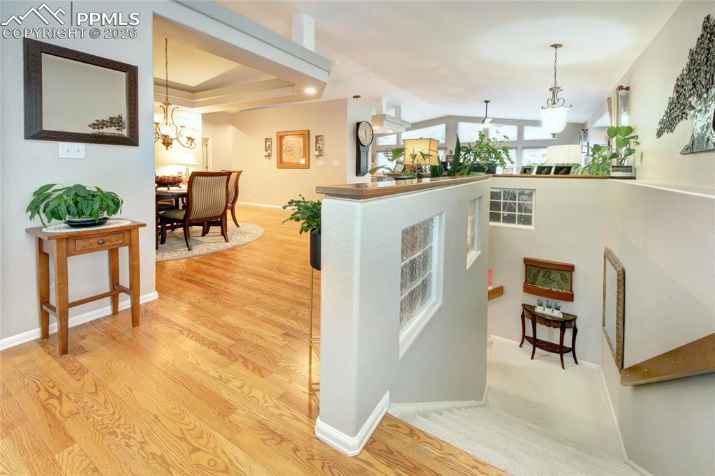 Image 27 of 50: Foyer hardwood looking down to basement
